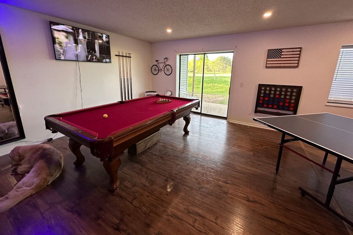 Spacious shared game room with pool table, ping pong, Connect 4, TV, board games and casual seating—perfect for relaxing or friendly competition after a day of adventure. Great for groups and families looking for fun during their stay!