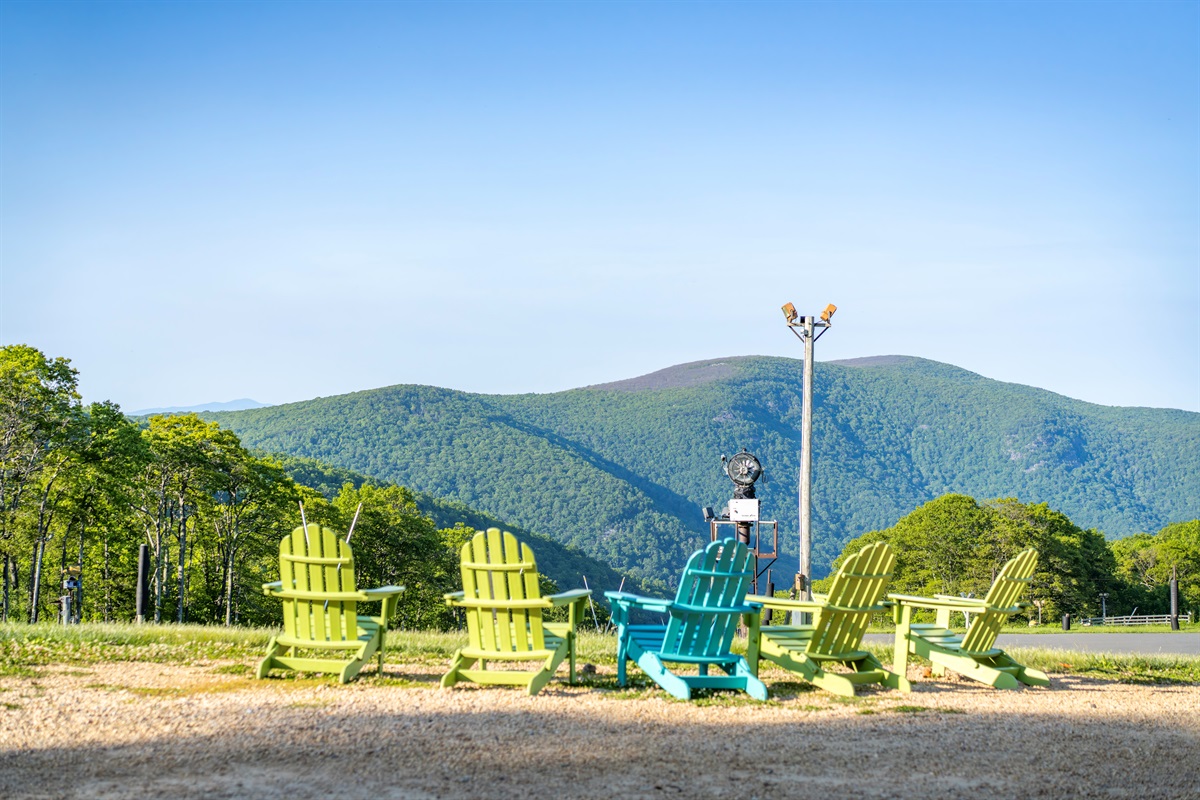 Colorful Adirondack chairs line the overlook, offering one of the best front-row seats to the Blue Ridge Mountains. Morning coffee or sunset wine—it hits different up here
