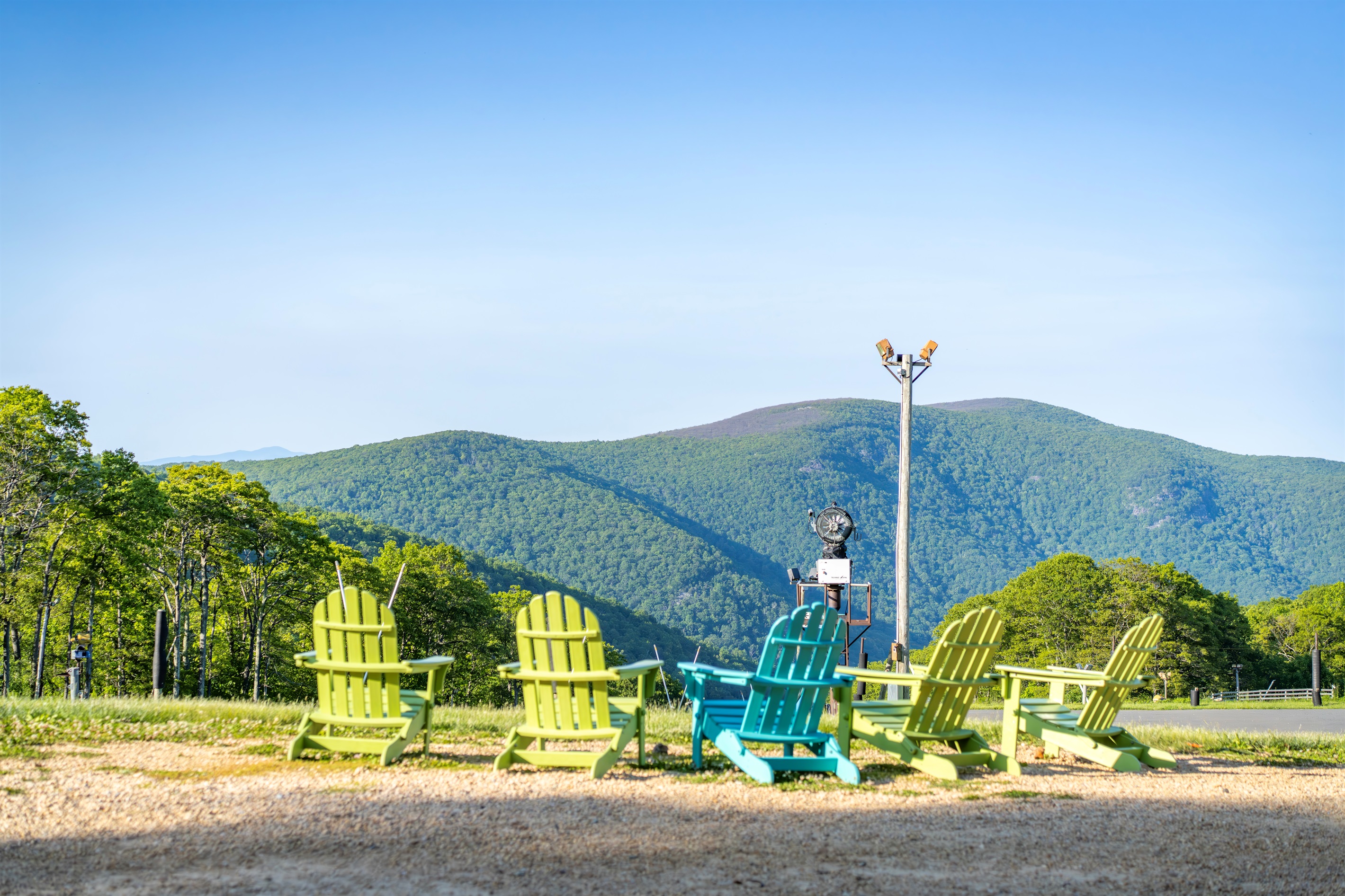 Colorful Adirondack chairs line the overlook, offering one of the best front-row seats to the Blue Ridge Mountains. Morning coffee or sunset wine—it hits different up here