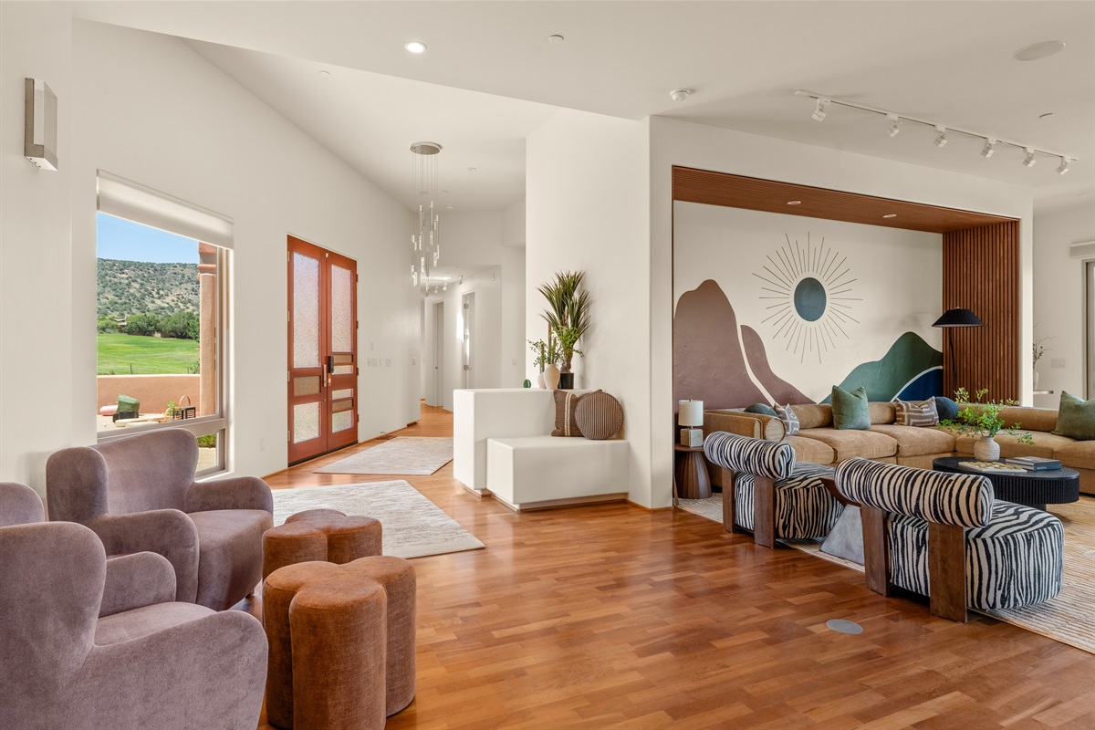 A grand arrival. The beautiful glass entryway flows seamlessly into the expansive living area, welcoming your group with striking architecture and abundant natural light.