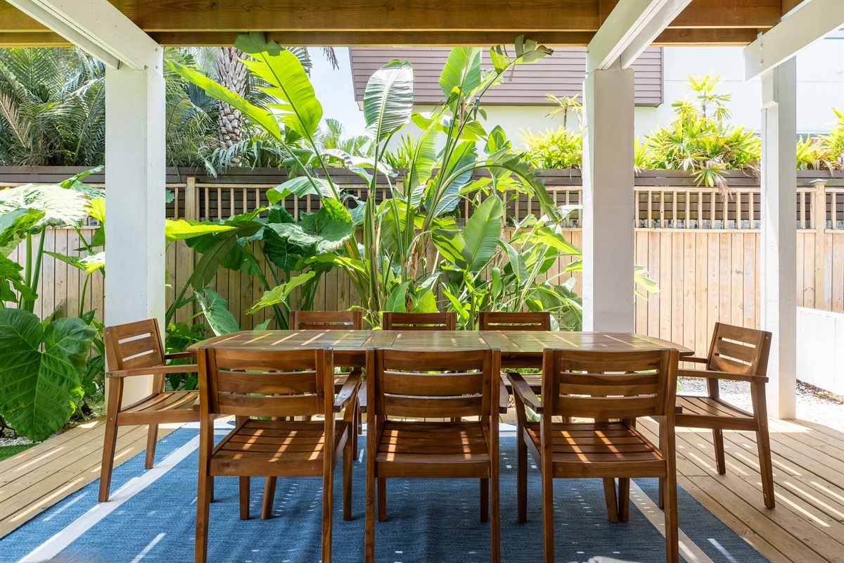 Gather for al fresco meals under lush tropical greenery.  This outdoor dining space is perfect for family dinners or laid-back grill nights