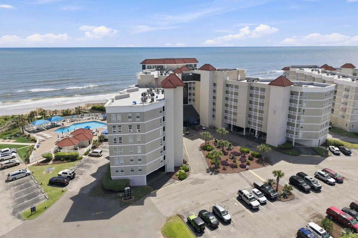 A wide-angle aerial view of the resort complex, nestled right along the coastline.