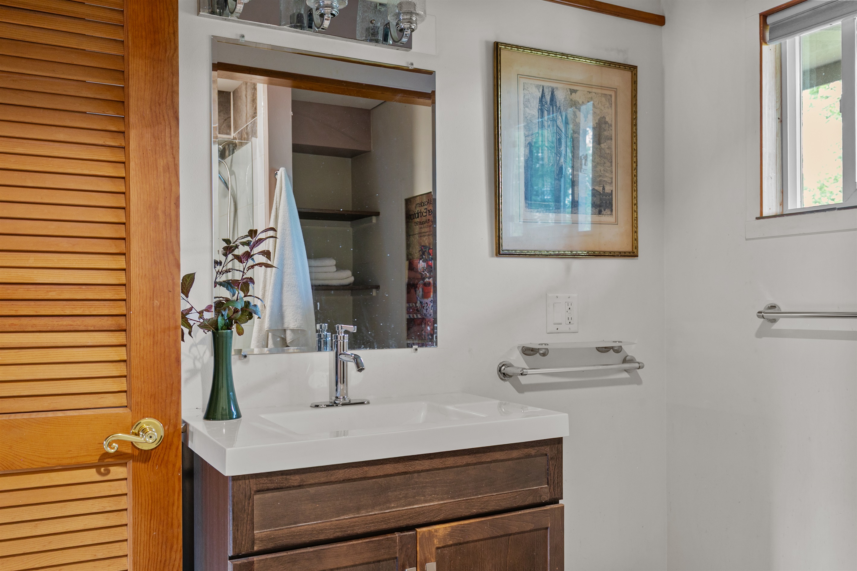 A modern sink with a built-in shelf keeps your toiletries neatly organized, making the en-suite both stylish and practical.