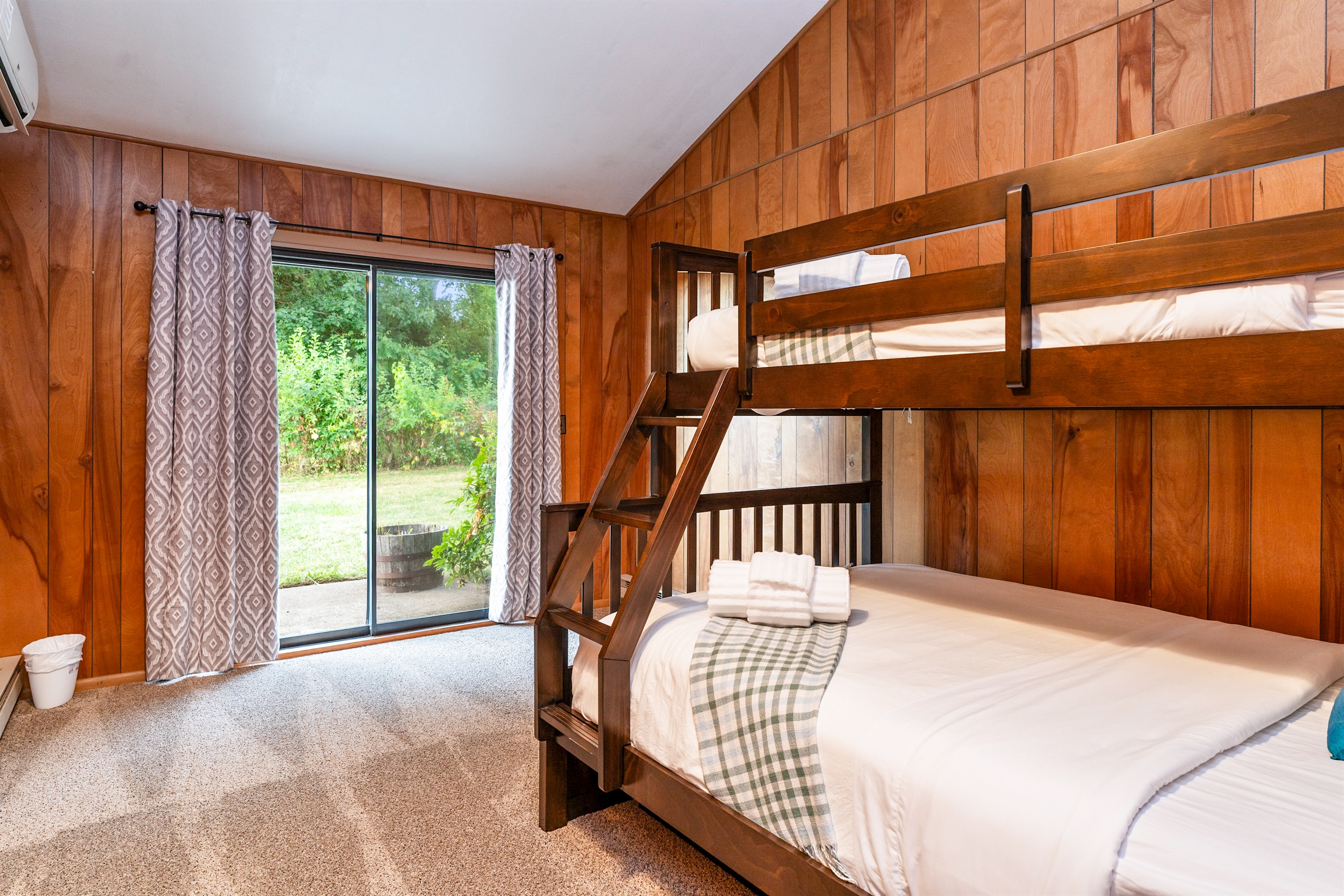 Cozy bunk room with sliding glass doors opening to the outdoors—perfect for kids or groups.