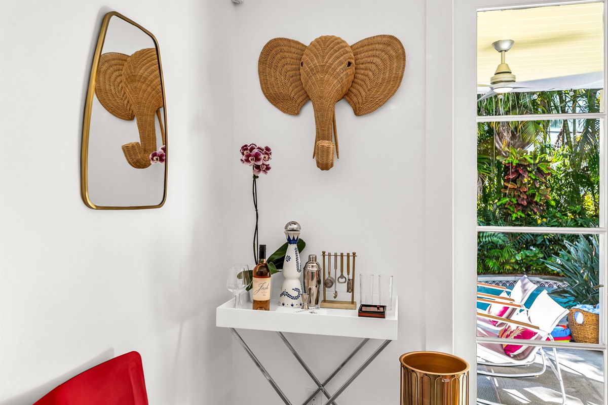 Bright and playful dining area with seating for eight, offering easy access to the kitchen and a discreetly tucked-away water closet. French doors open directly to the patio and pool deck for effortless indoor-outdoor entertaining.