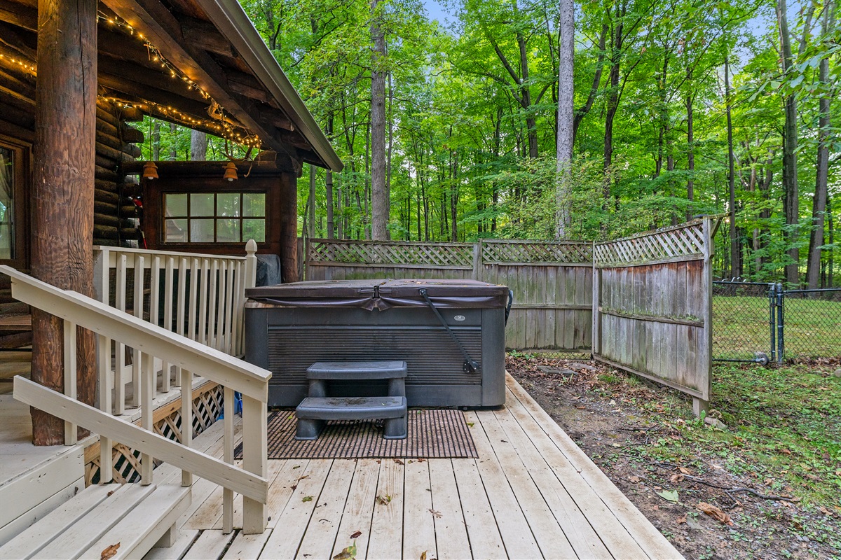 Relax in the private hot tub tucked into a wooded setting, perfect for unwinding after a day of adventure.