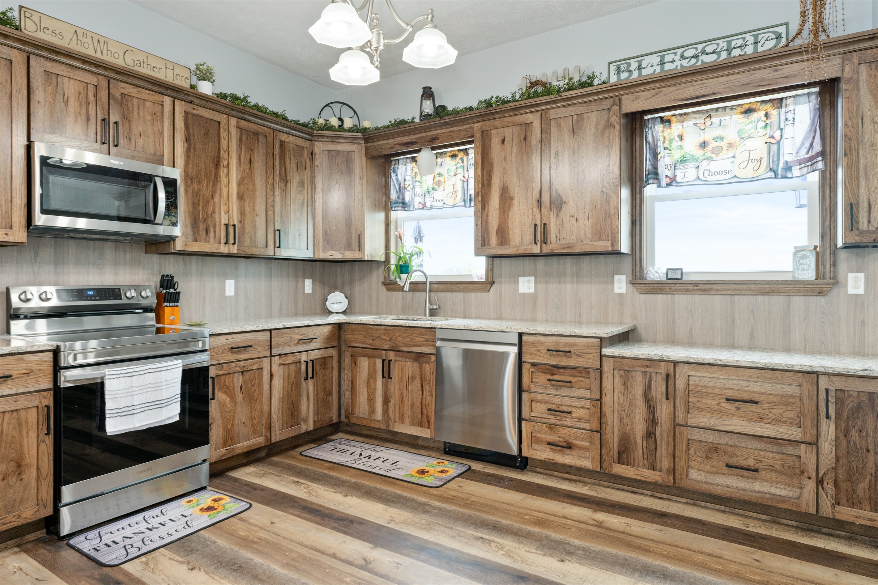 Beautiful farmhouse-style kitchen with warm wood cabinetry, granite counters, and a spacious island with bar seating for four.