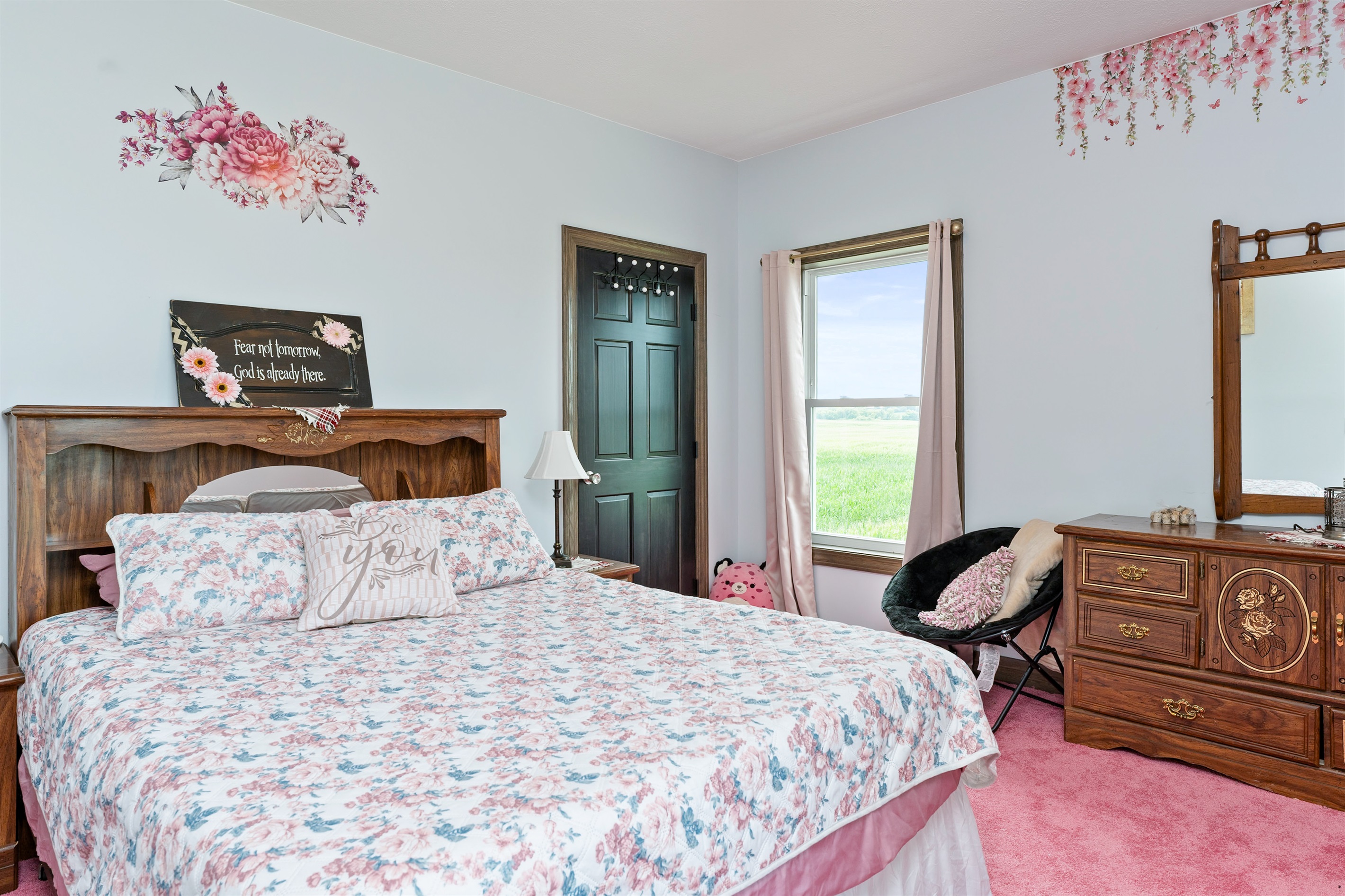 Bright and inviting Queen bedroom with floral touches, vintage wood furnishings, and serene country views right outside the window. Bedroom #2