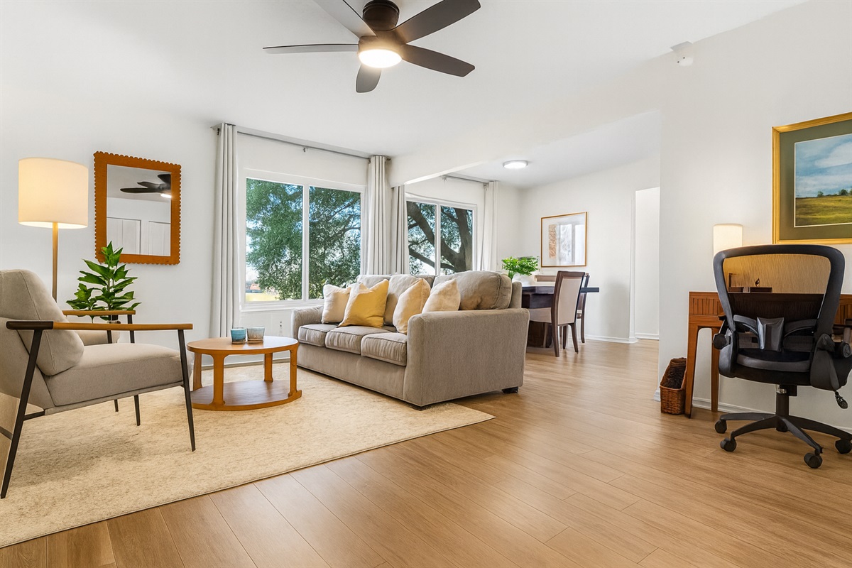 Inviting and open main living space with ceiling fan, plush seating, and plenty of natural light.