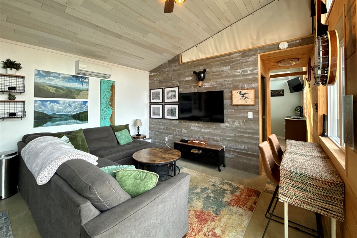 Natural light, thoughtful artwork, and sweeping views make the living room feel warm, simple, and inviting.