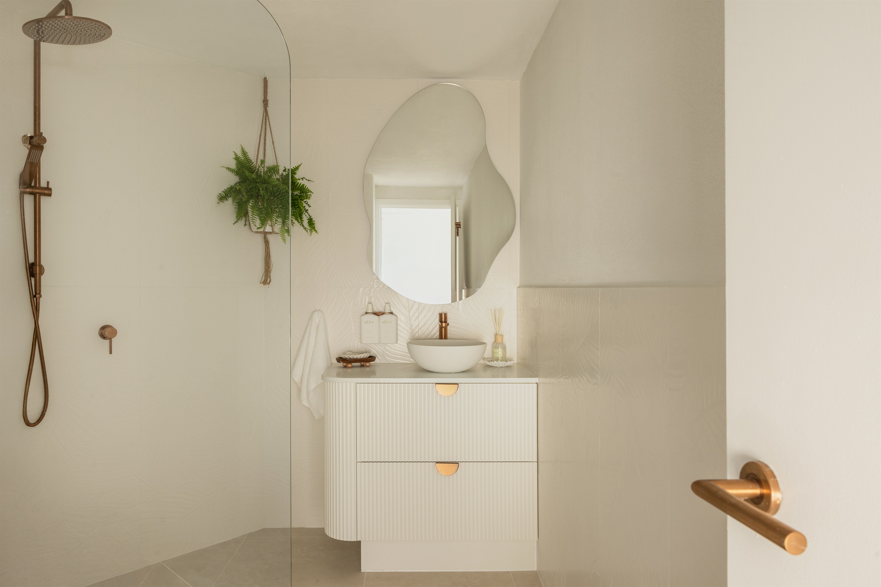 Newly renovated coastal bathroom featuring premium brushed-copper fixtures, walk-in shower + quality essentials.