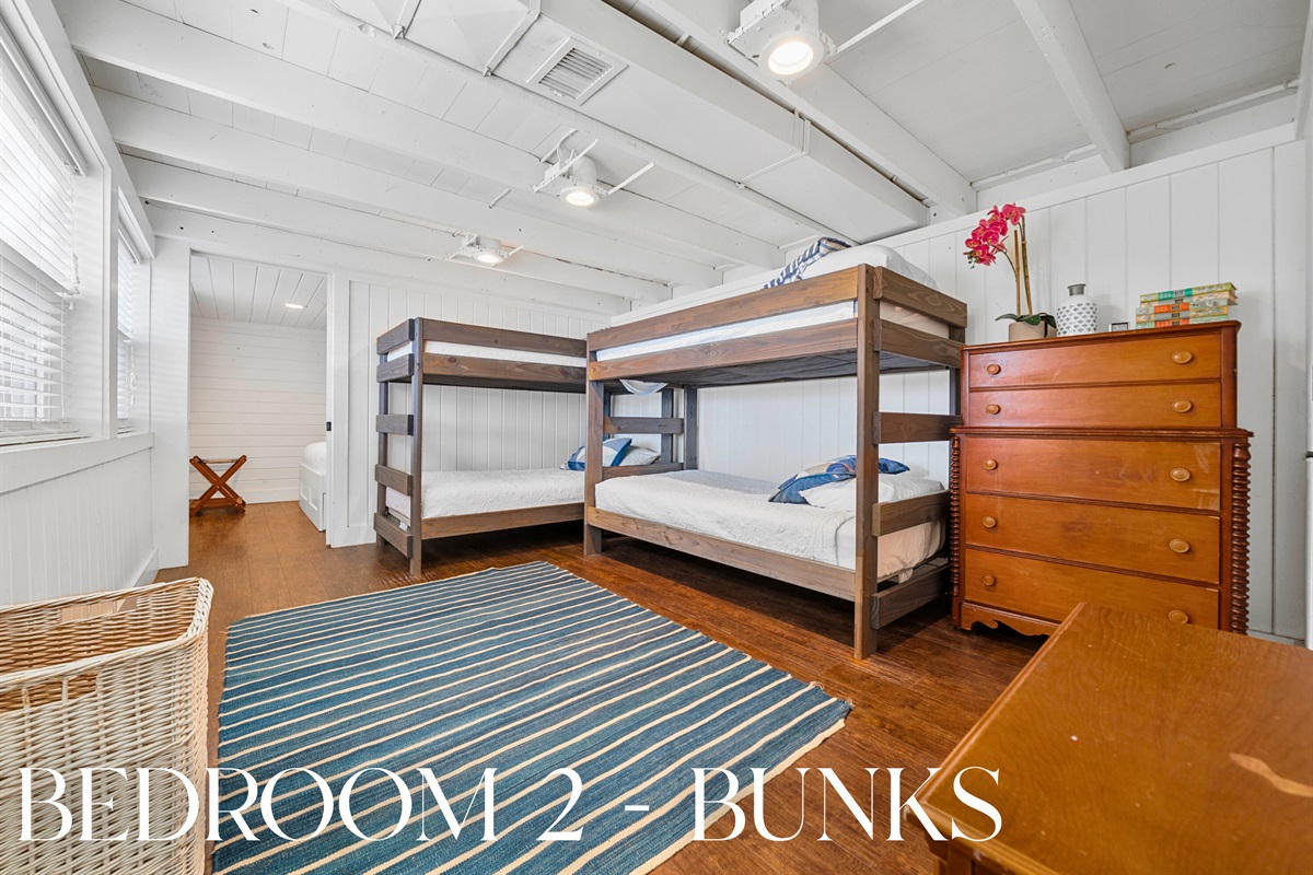 The bunk room setup has a cozy rug and warm fireplace for evening hangouts.