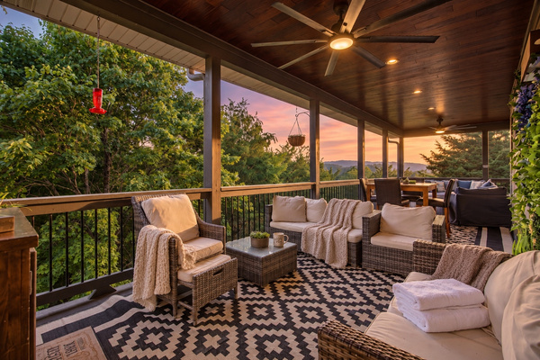 Covered back deck with outdoor sectional, TV and ceiling fans overlooking the mountains