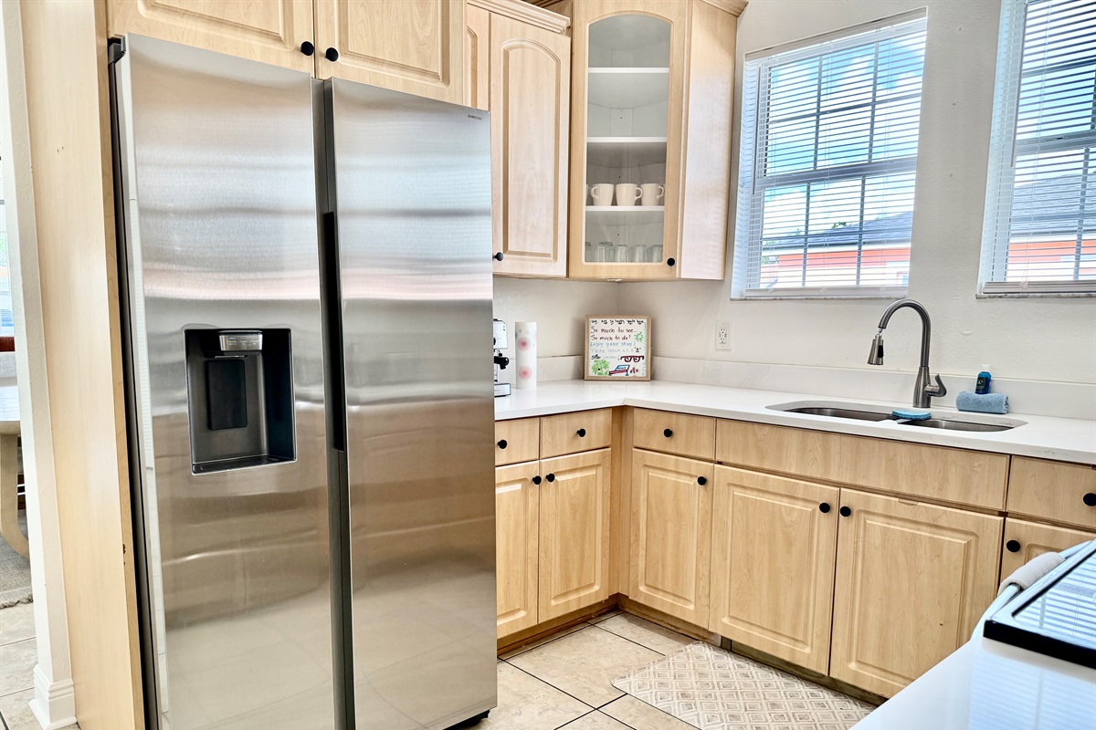 Natural wood cabinetry meets clean white countertops in this charming kitchen designed for both form and function.