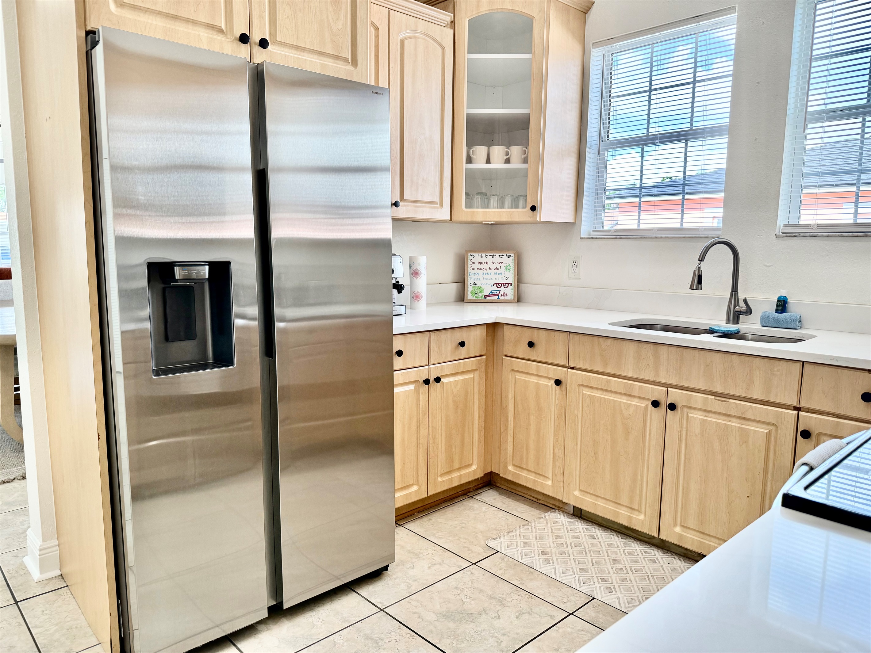 Natural wood cabinetry meets clean white countertops in this charming kitchen designed for both form and function.