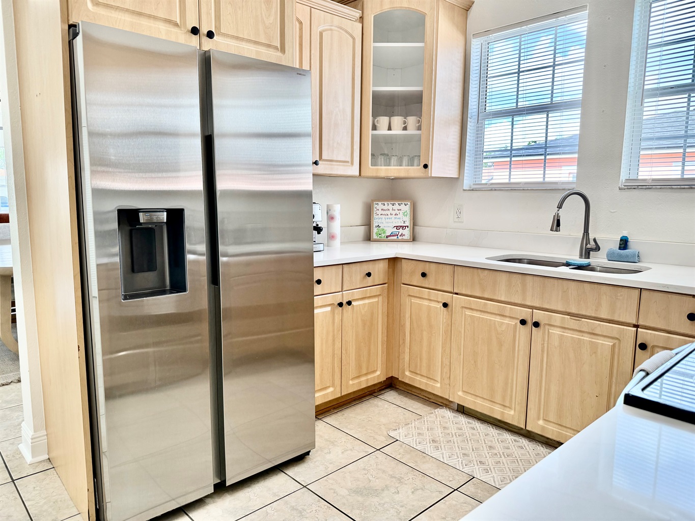 Natural wood cabinetry meets clean white countertops in this charming kitchen designed for both form and function.