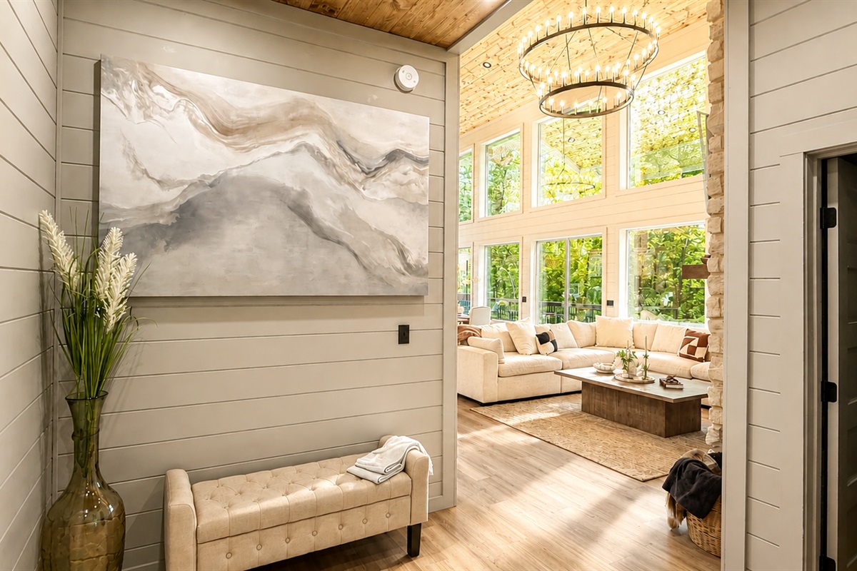 Living Room: Sunlit space with large windows, plush seating, and a stylish art piece awaits you!