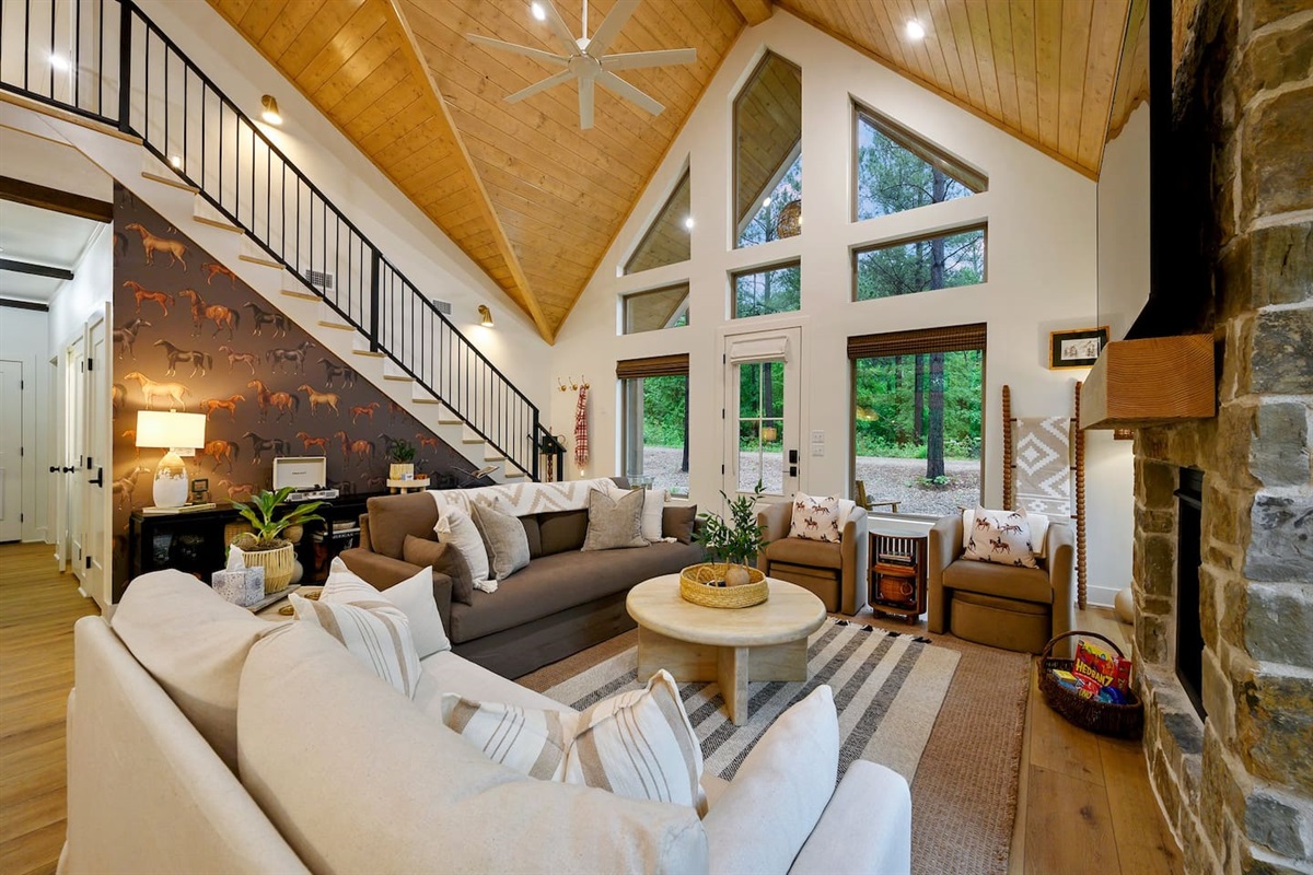 Soaring vaulted ceilings, stunning trapezoid windows, and curated design details make this living room a cozy yet refined retreat.