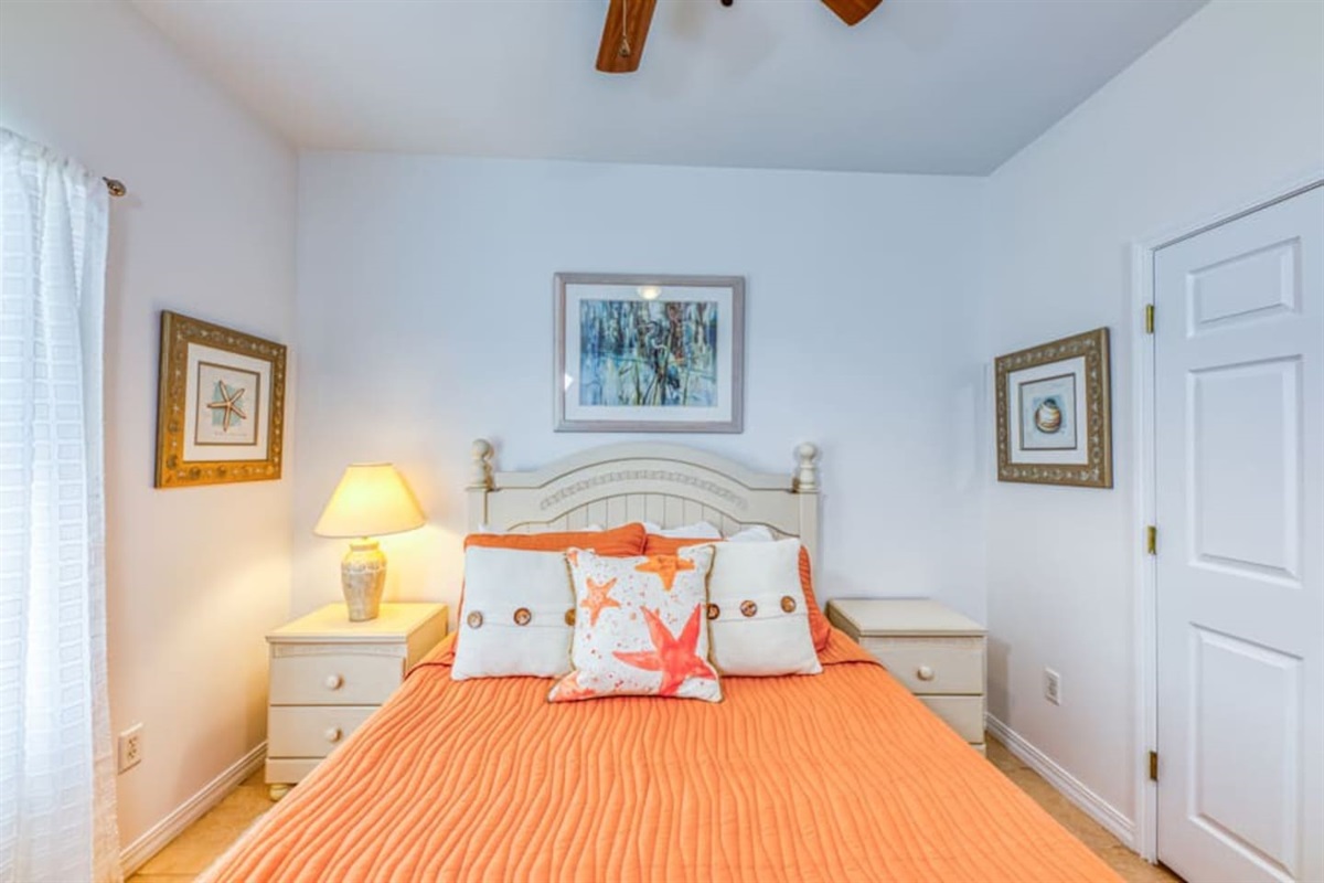 Bedroom Retreat: Bright, airy room with beach-inspired décor and vibrant orange accents!