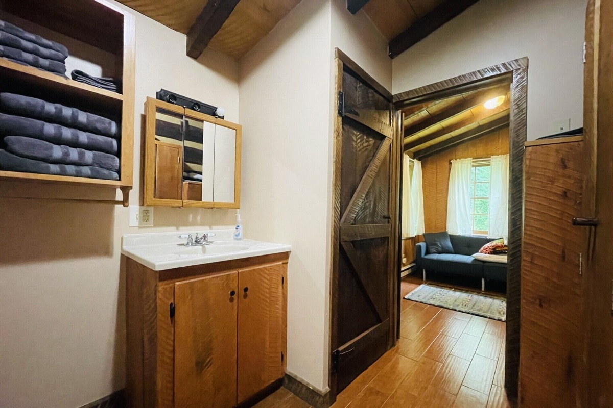 Stacking washer and dryer for guest use behind barn door.