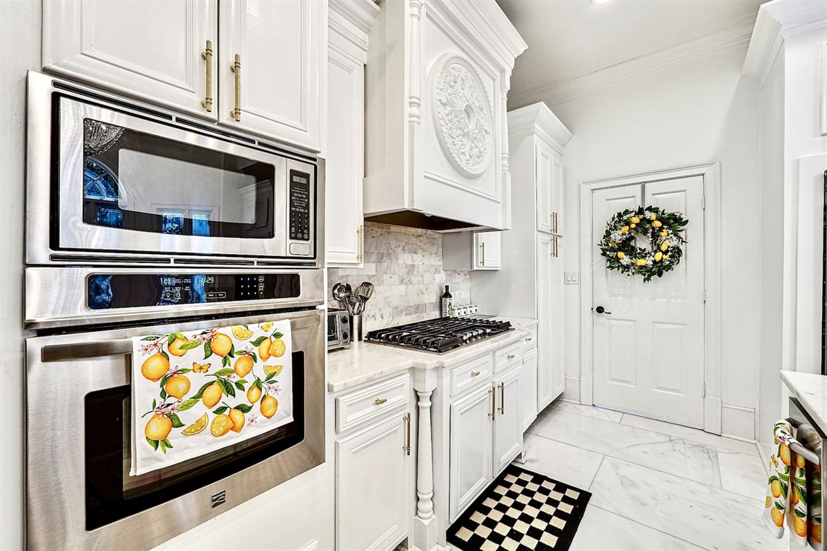 Bright and beautifully designed kitchen with white marble counters and white wood cabinetry. Fully equipped and ideal for cooking, gathering, and hosting with ease.