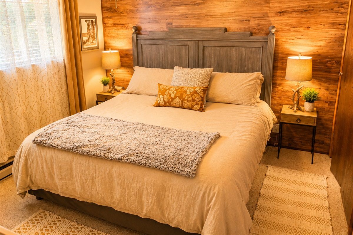 This bedroom is one of two bedrooms on the first floor of the cabin.  It has a king size bed, two nights stands with reading lights, room darkening shades with curtains, baseboard heating, a closet and dresser.
