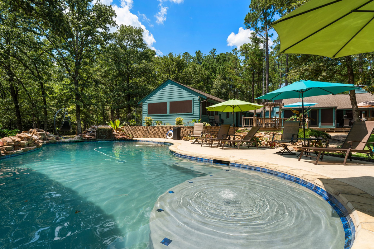 The custom pool is the crown jewel of Teal Paradise, offering a heated oasis (POOL HEATING IS AVAILABLE FOR A $300/night fee) with a swim-up bar, waterfalls, a jump-off pad, and a mesmerizing rain curtain. A six-person hot tub, nearby fire p