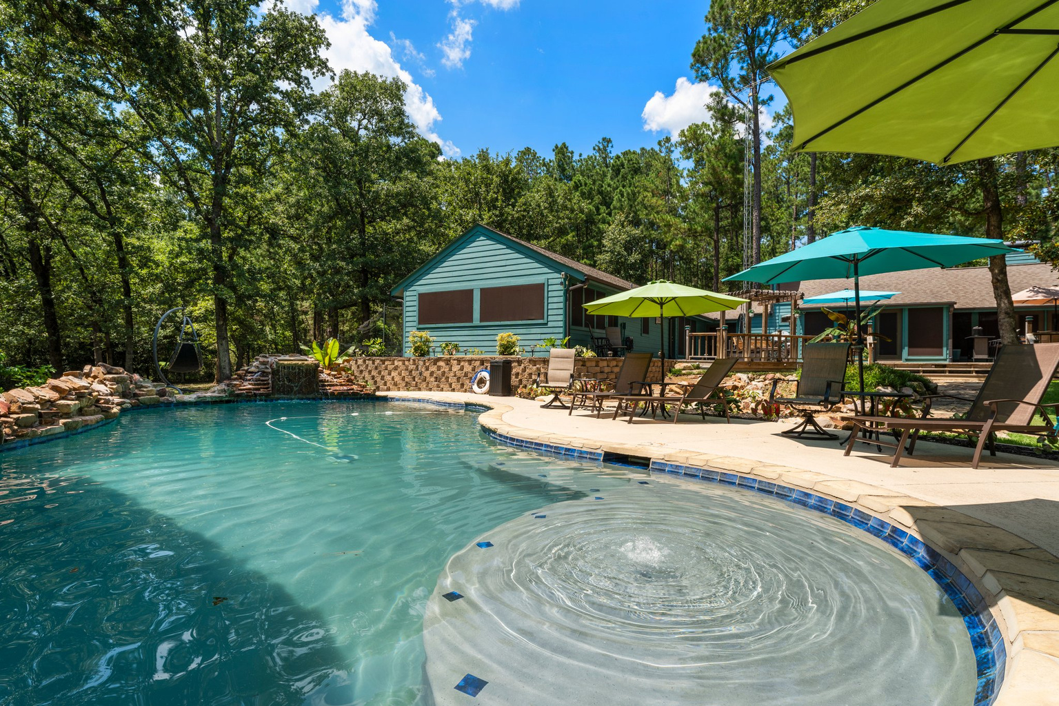 The custom pool is the crown jewel of Teal Paradise, offering a heated oasis (POOL HEATING IS AVAILABLE FOR A $300/night fee) with a swim-up bar, waterfalls, a jump-off pad, and a mesmerizing rain curtain. A six-person hot tub, nearby fire p