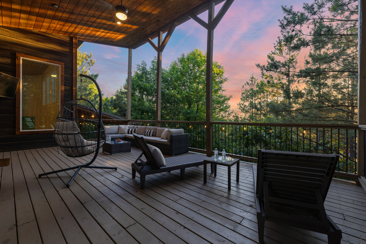 A cozy patio setup featuring lounge seating and an outdoor TV for easy, laid-back entertainment outside.