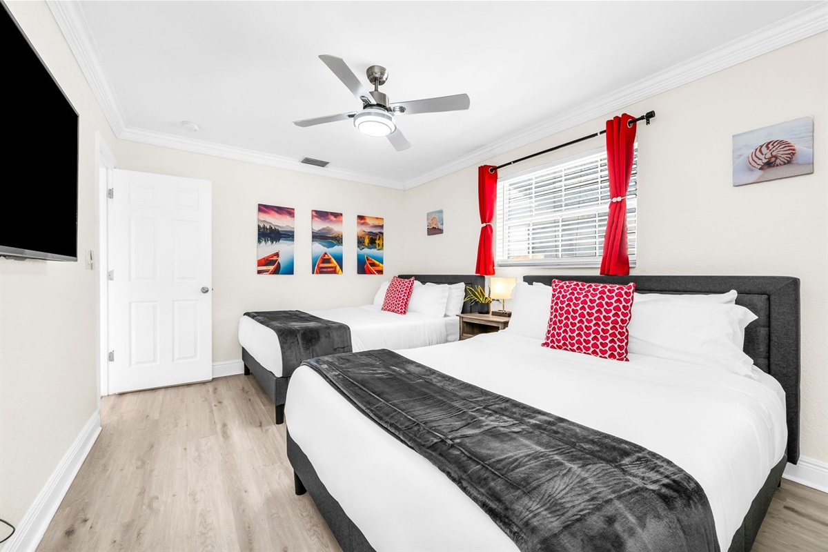 This inviting ensuite bedroom offers two plush queen beds, a smart TV for cozy nights in, and plenty of closet space plus a built-in vanity mirror for getting ready.