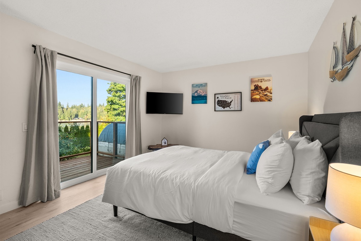 Wake up to peaceful waterviews from this serene queen bedroom, styled with soft cotton linens