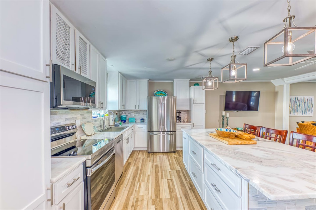 Kitchen: Sleek design meets coastal charm with gleaming appliances and inviting island seating!
