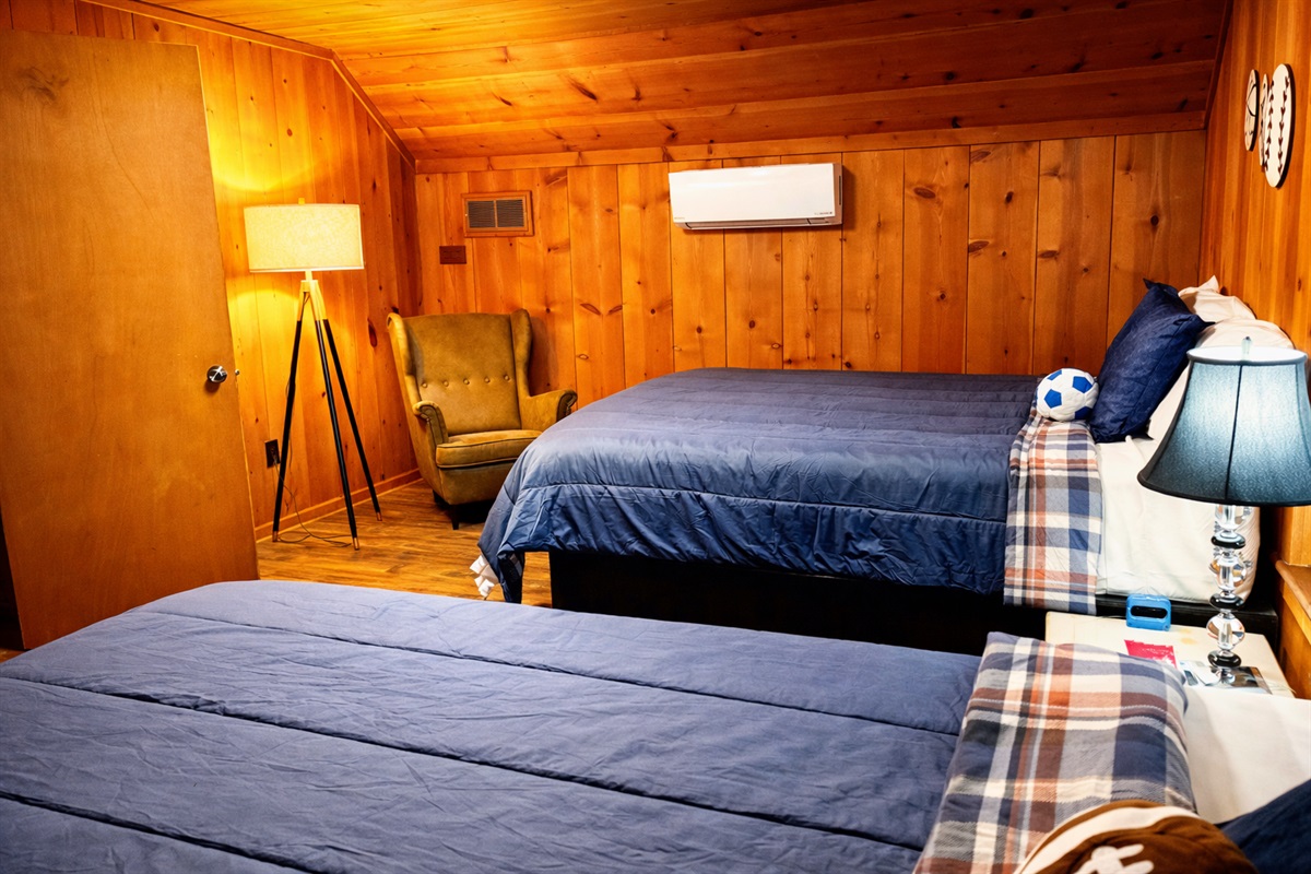Sleep soundly in this inviting cabin bedroom featuring plush bedding, rustic wood interiors, and a cozy reading nook.