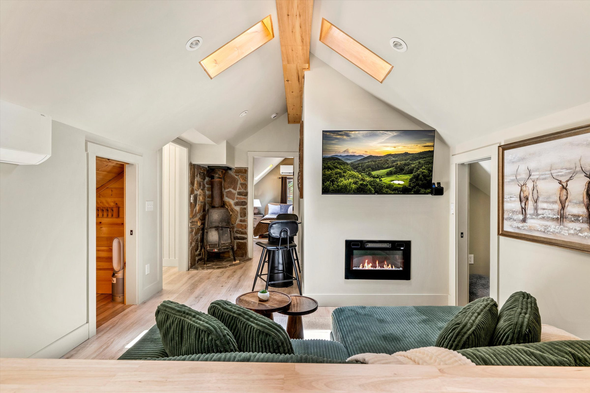 The Penthouse: Cozy Living Room with 55-inch Smart TV, Fireplace, and bistro table.
