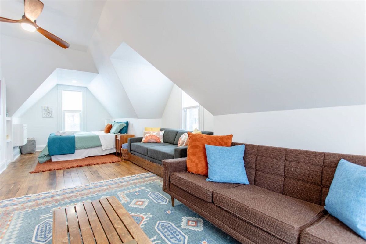 A living area seamlessly integrated into the bedroom, featuring a comfy seating arrangement that allows for both relaxation and a cozy, multi-functional space.