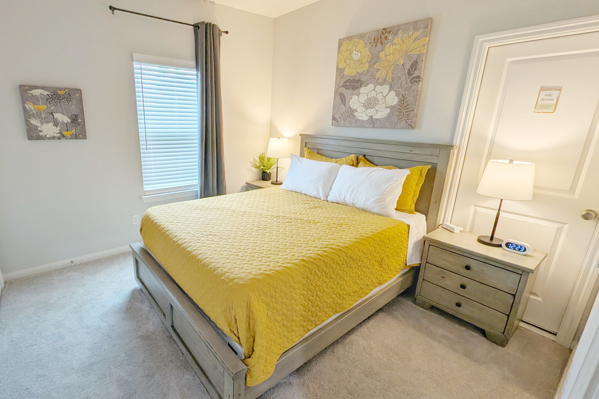 Relax in this cozy Queen bedroom with blackout curtains and a ceiling fan.