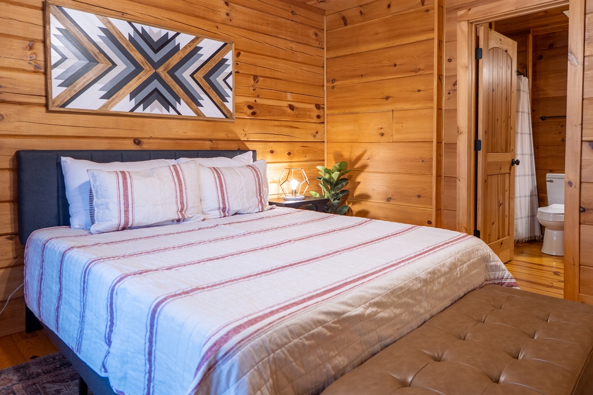 The Sapphire Owl's main-level bedroom features a comfortable queen-size bed and direct access to its en-suite bathroom for ultimate convenience.