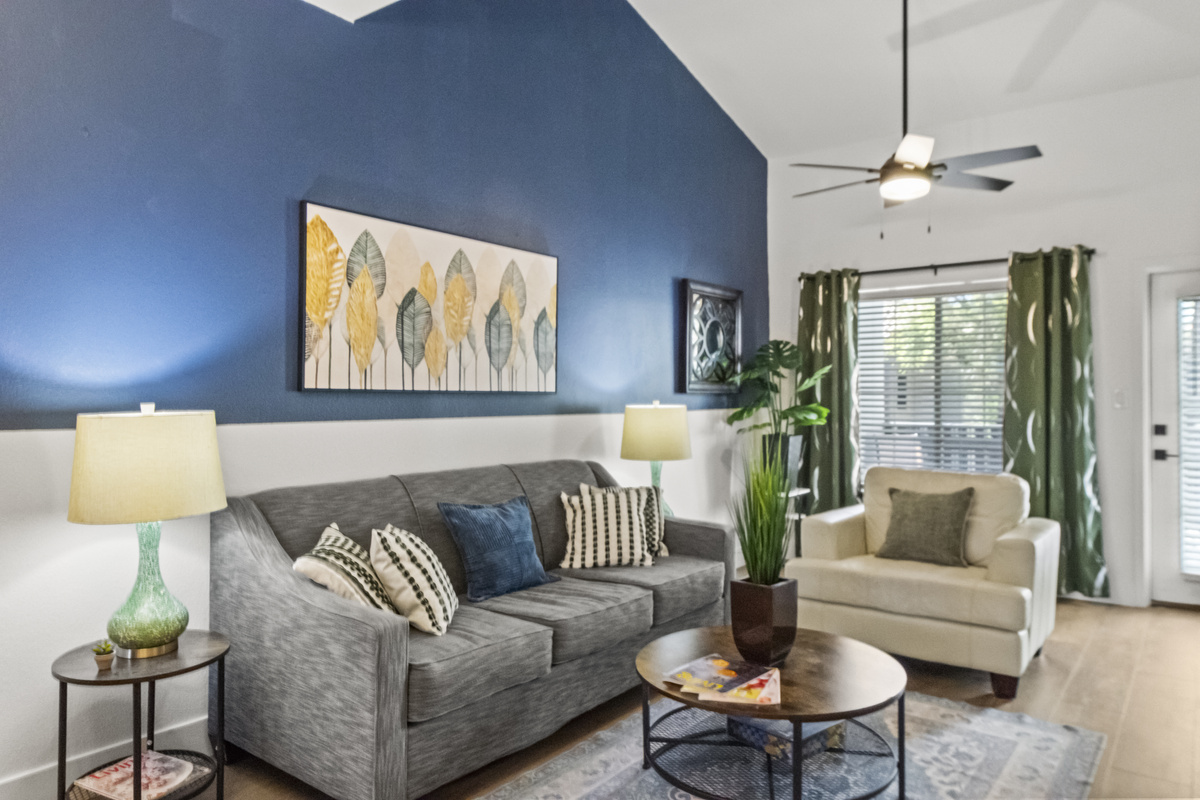 Spacious living room with a Roku smart TV, work desk, a fire place and a snug couch for added comfort. 