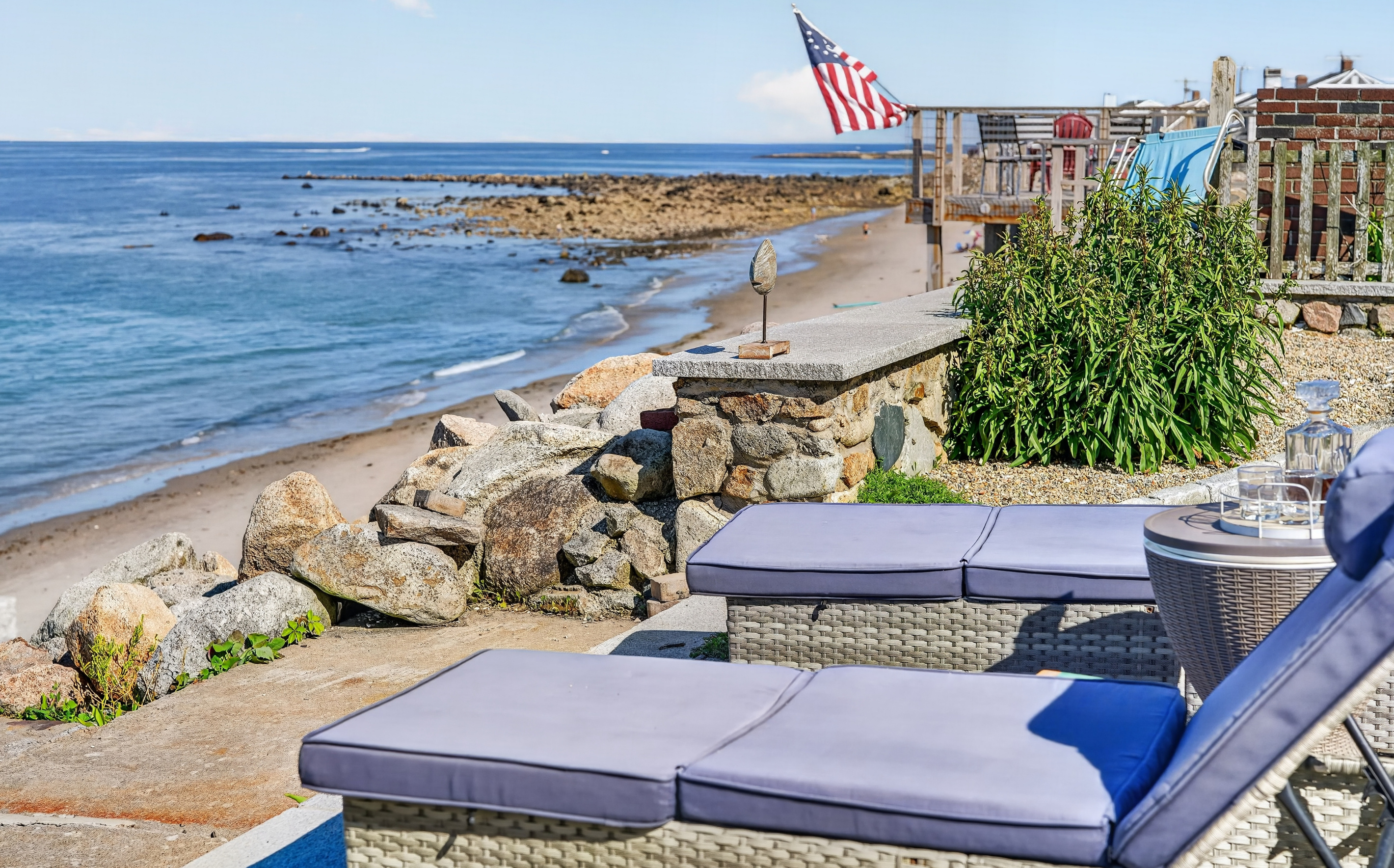Private oceanfront patio with comfortable lounge seating just steps from the shoreline
