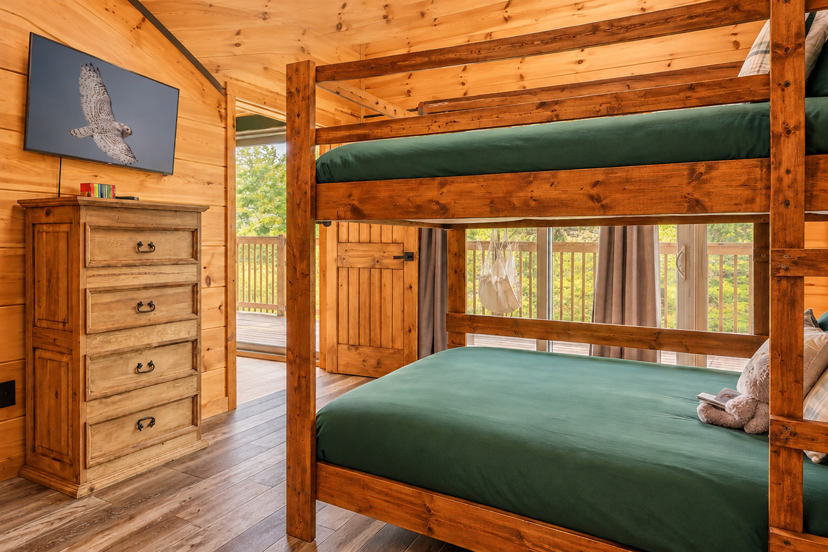Stacked bunks, flat-screen, tall chest of drawers, and a hammock chair outside.