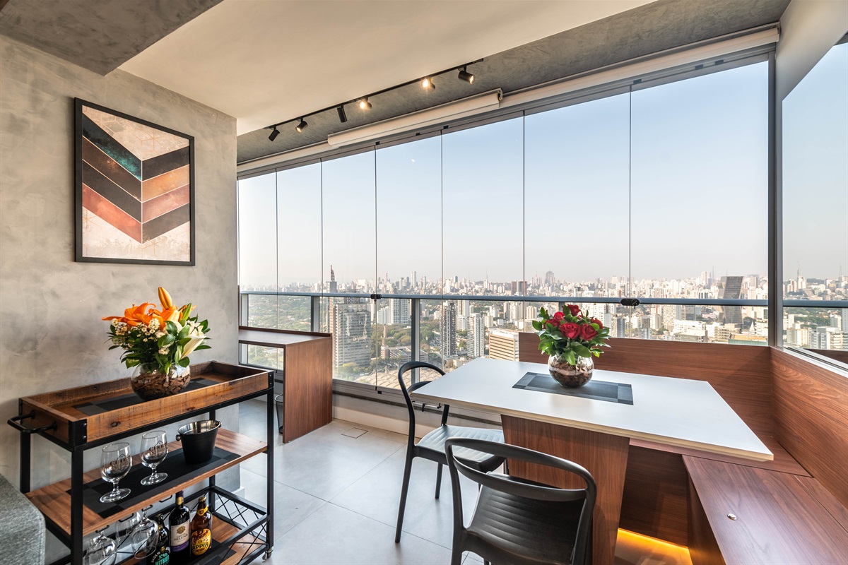 Área de jantar completa 🍽️ Área de jantar integrada à varanda, com mesa para até 4 pessoas e vista panorâmica de São Paulo. Ambiente moderno e acolhedor no River One.