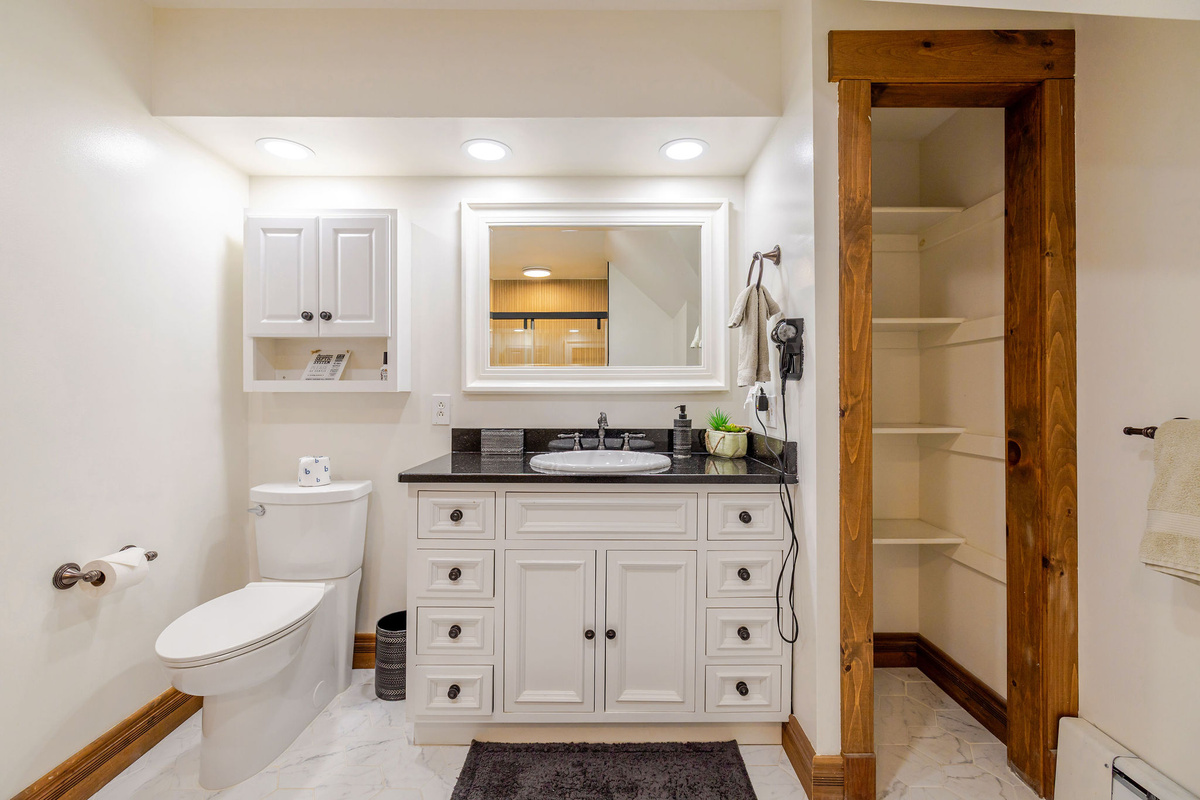 The shared upstairs bathroom features a spacious vanity with plenty of storage, making it easy for everyone to get ready for the day's Adirondack adventures.