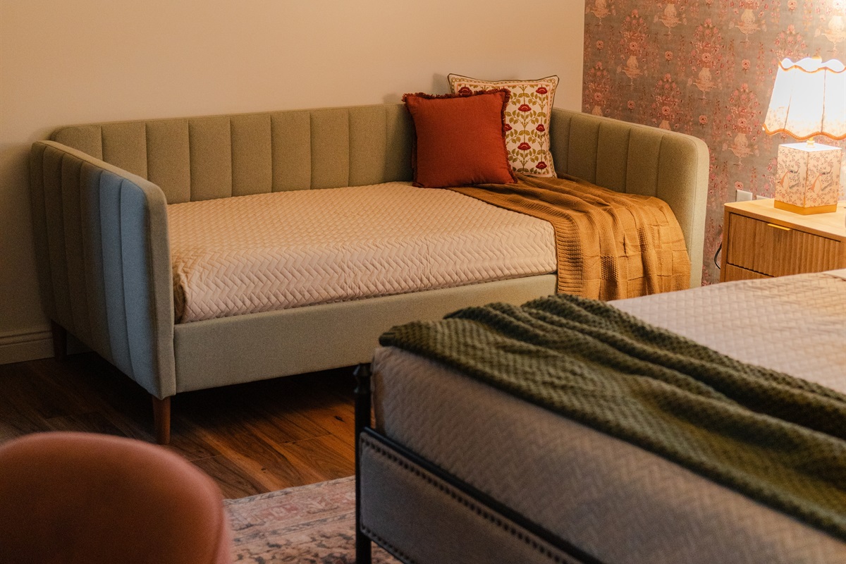 Enjoy a comfortable bedroom setup with added sleeping space from the daybed.
