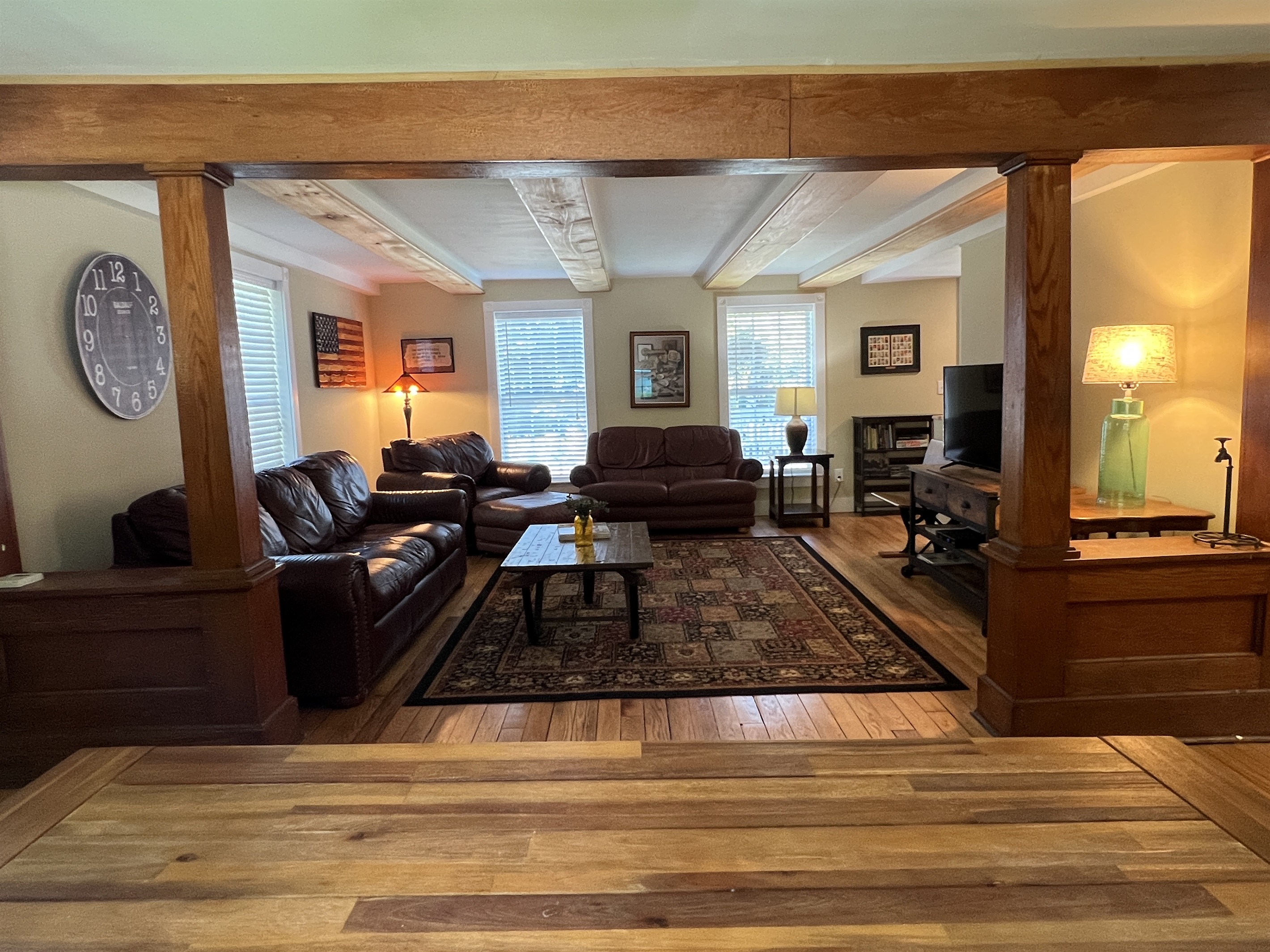 Living room with hardwood floors and original columns.