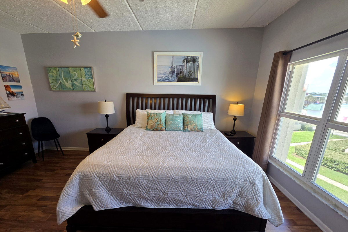 Relax in a bright king bedroom with coastal decor and views of lush grounds.