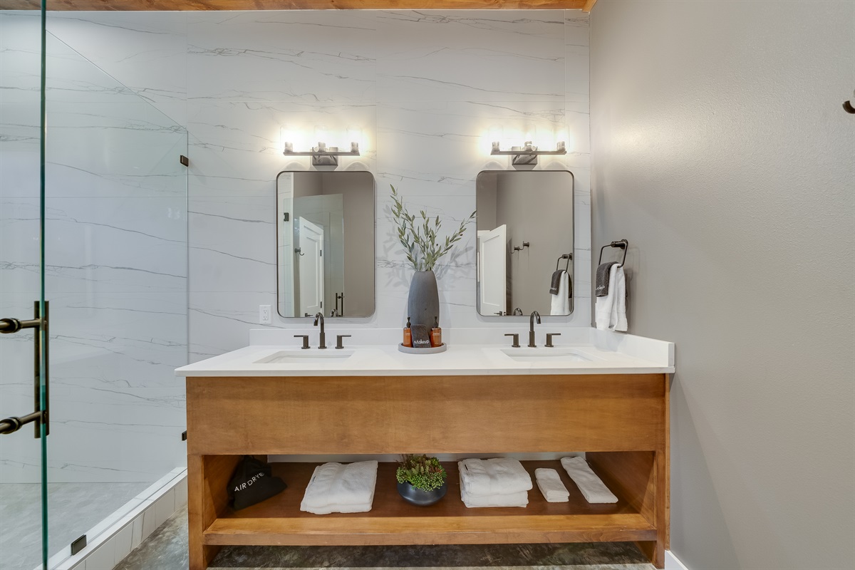 Ensuite Bathroom 1 - Private bathroom attached to King Suite 1. Featuring oversized shower with dual showerheads and spa-quality marble finishes. Includes premium toiletries (body wash, shampoo, conditioner, hand soap) and hotel quality towels. 