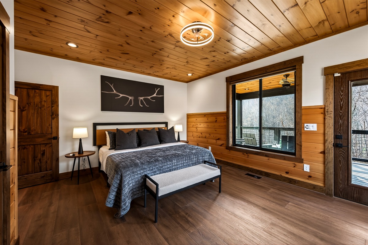 Relax in the spacious main level king bedroom with a large TV, dedicated desk & direct deck access. Unwind in the en-suite bathroom featuring a walk-in shower with a natural river rock floor, bringing  the Smoky Mountains indoors for a spa retreat.