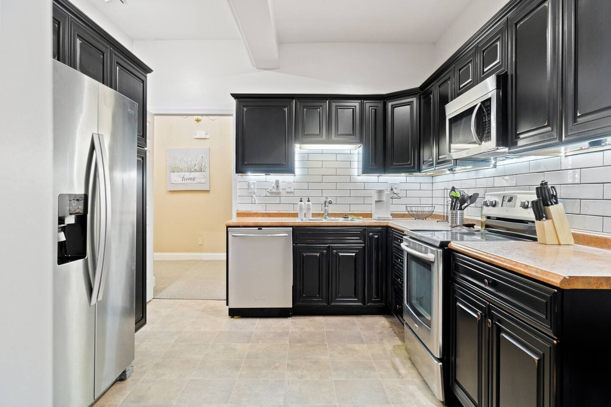 Fully equipped with modern kitchen appliances, including a sleek refrigerator, stove, and microwave, for a convenient and enjoyable cooking experience.