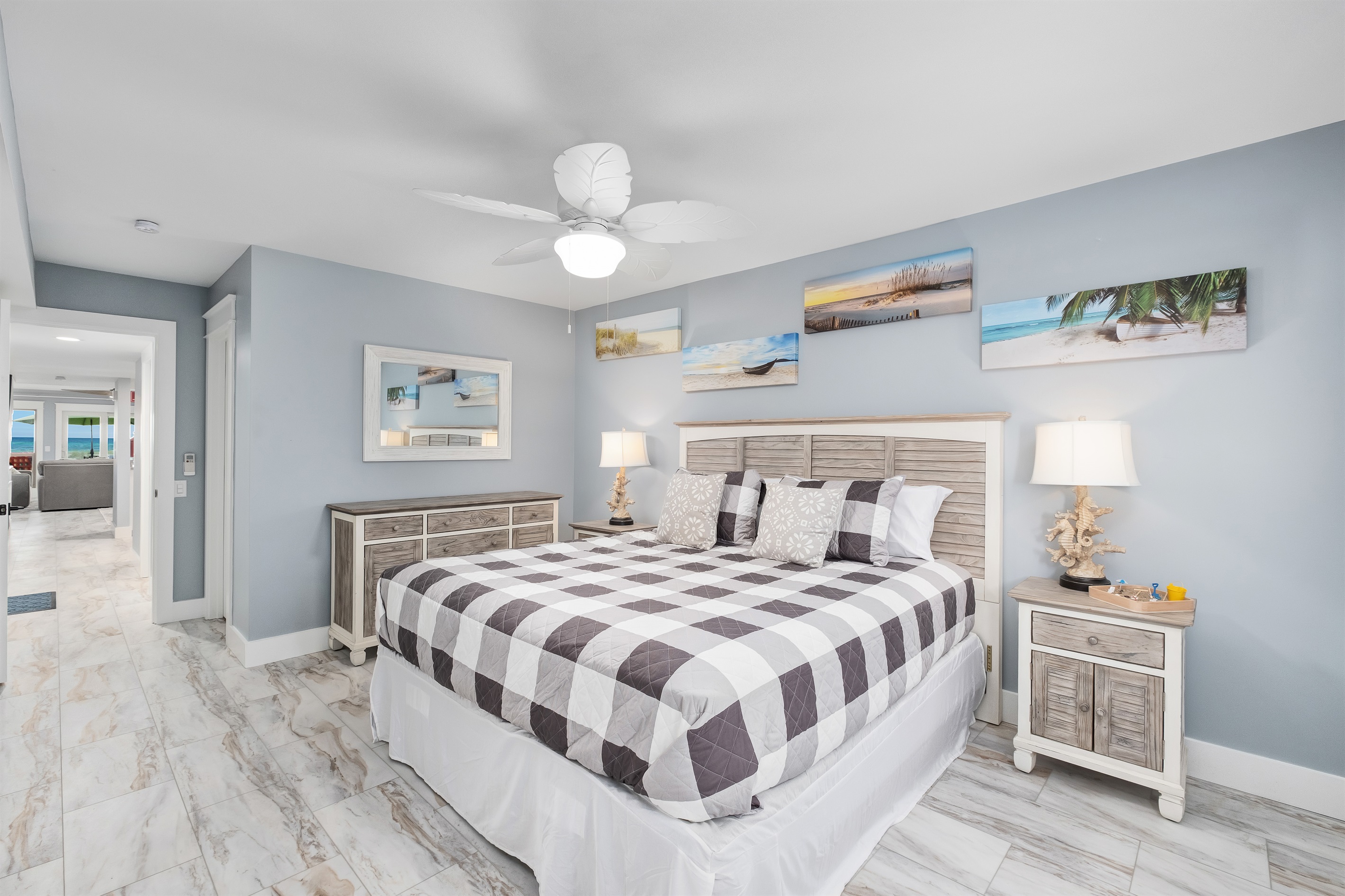 Unwind in the comfortable master bedroom featuring a king bed and beach-themed decor.