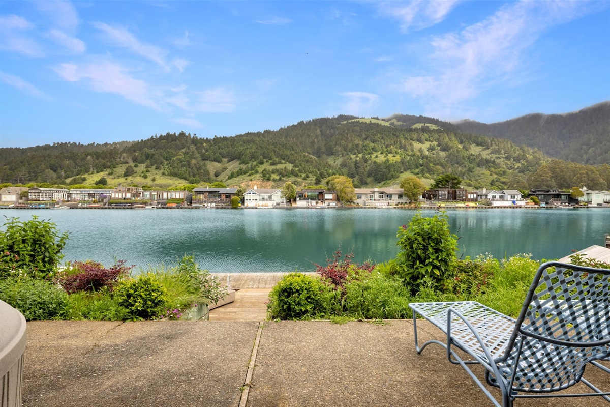 Patio seating with serene lake and mountain views.

